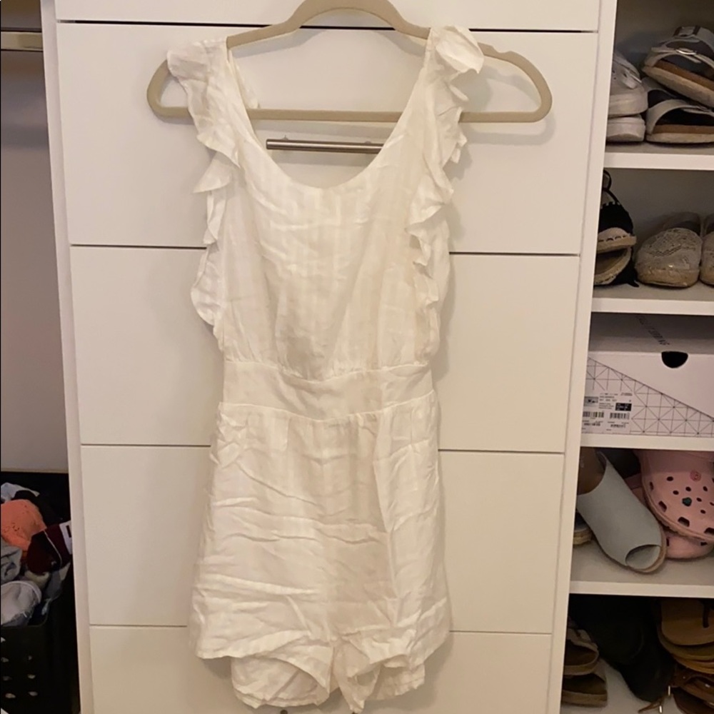 White, open back romper. Has light stripes